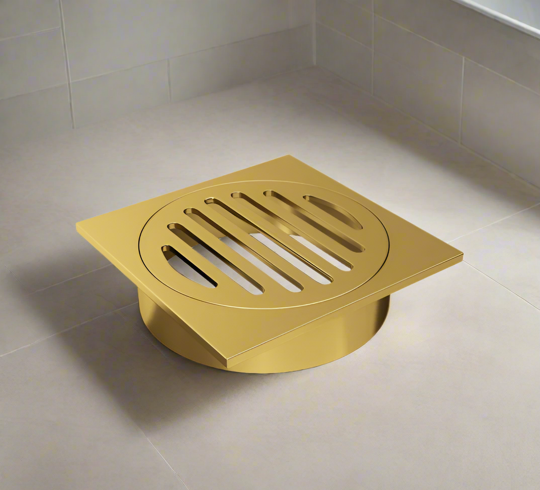 A black square floor waste drain grate installed on a tiled bathroom floor.