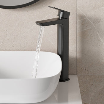 Black faucet with water flowing into a white sink against a beige tiled wall.