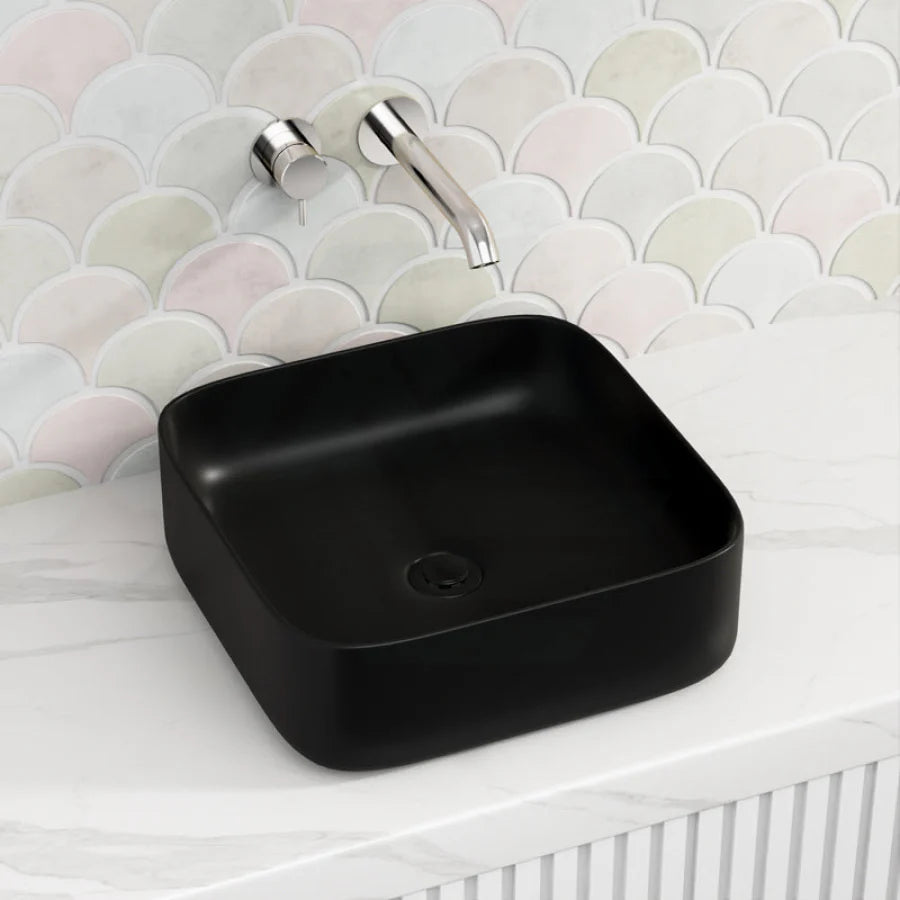 Black square sink with silver faucet against a patterned wall