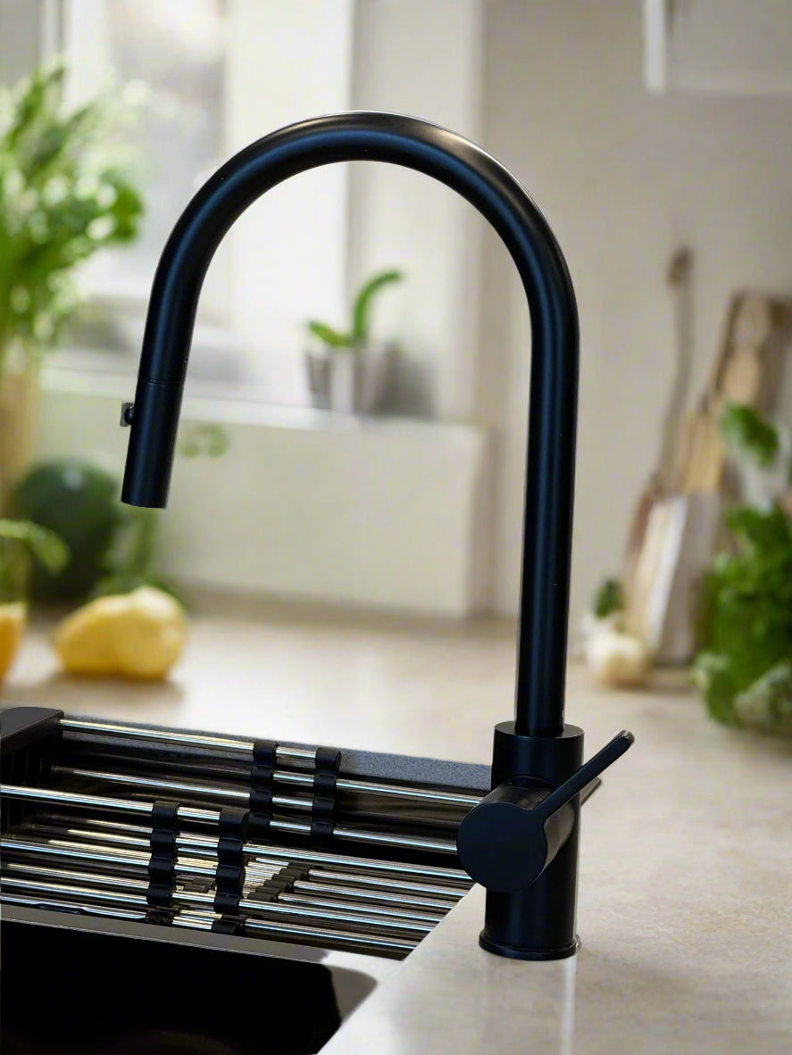 A modern matte black pull-out kitchen sink mixer tap in a kitchen setting.