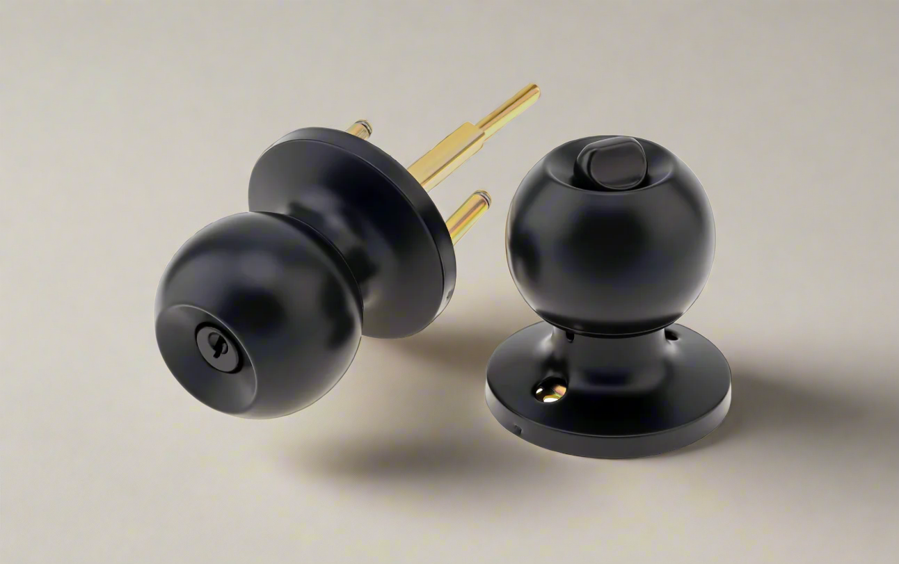 A set of two ball door knobs with a matte black finish and a metallic spindle behind them, placed against a light background.