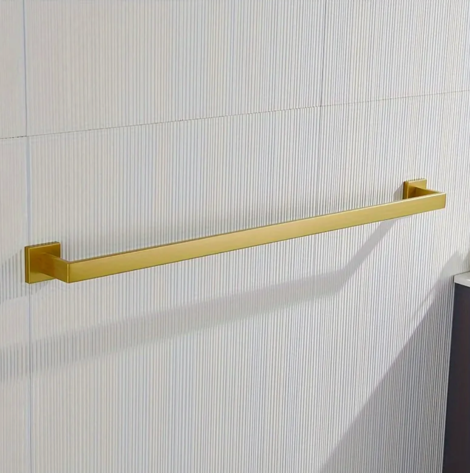 Gold towel bar mounted on a tiled bathroom wall