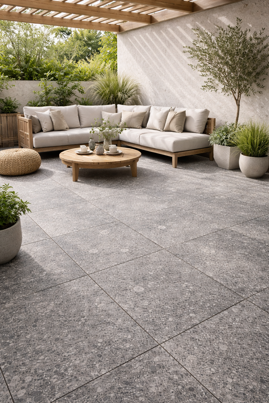 Outdoor patio with stone tiles, a sectional sofa, and potted plants.