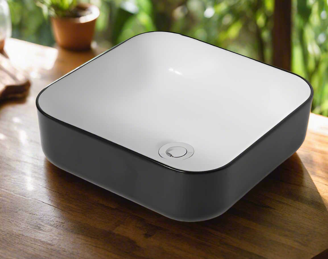 A modern square-shaped ceramic wash basin with a matte black finish, displayed above a wooden surface.