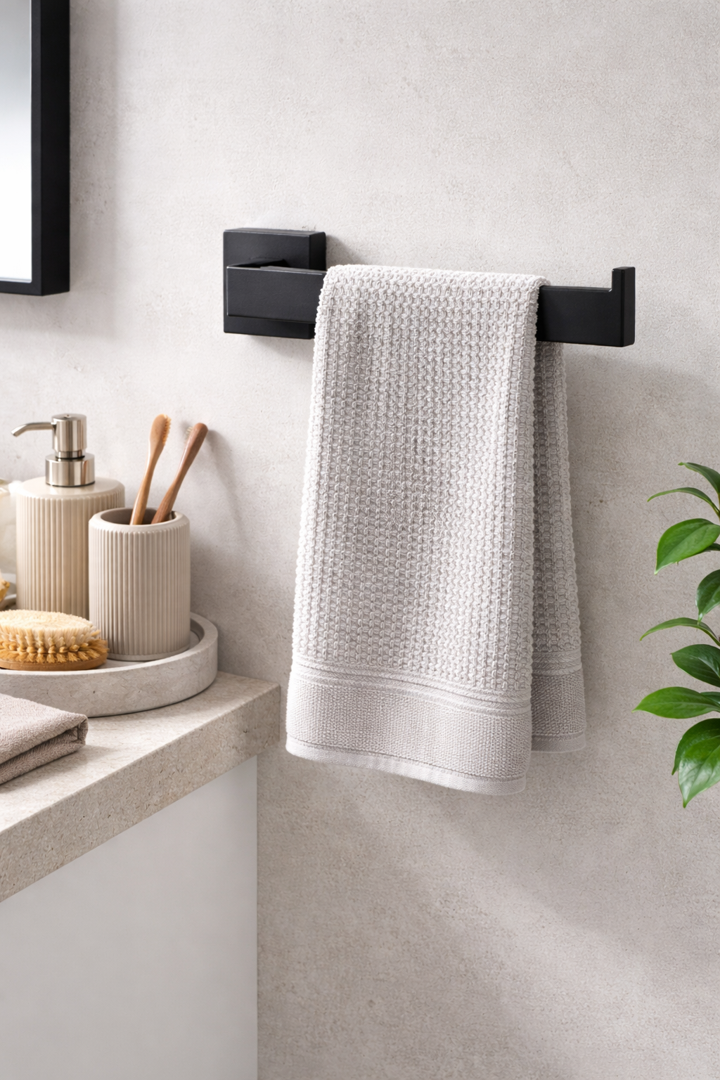 White textured towel hanging on a black towel rack in a bathroom.