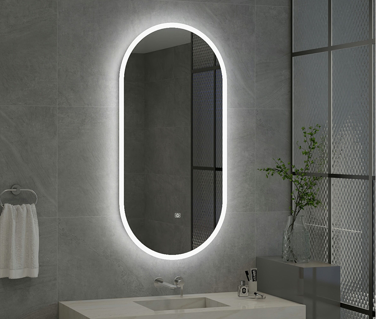 Bathroom with a large oval mirror with LED lighting on a gray tiled wall.