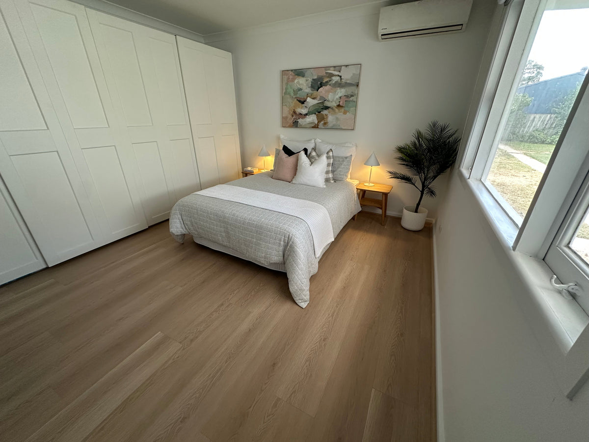 Blonde Oak laminate flooring installed in a furnished bedroom