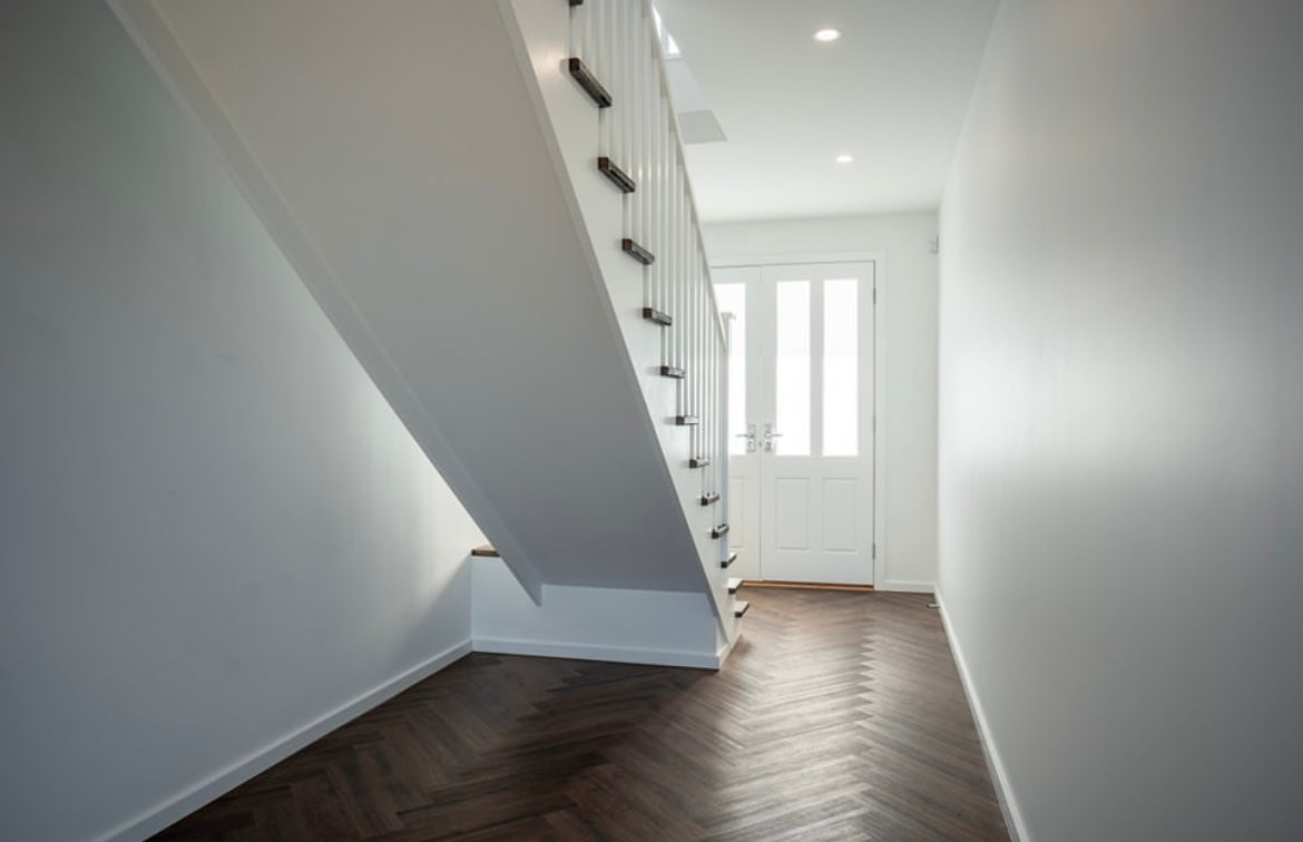 Dark oak hybrid herringbone flooring installed in a bright hallway