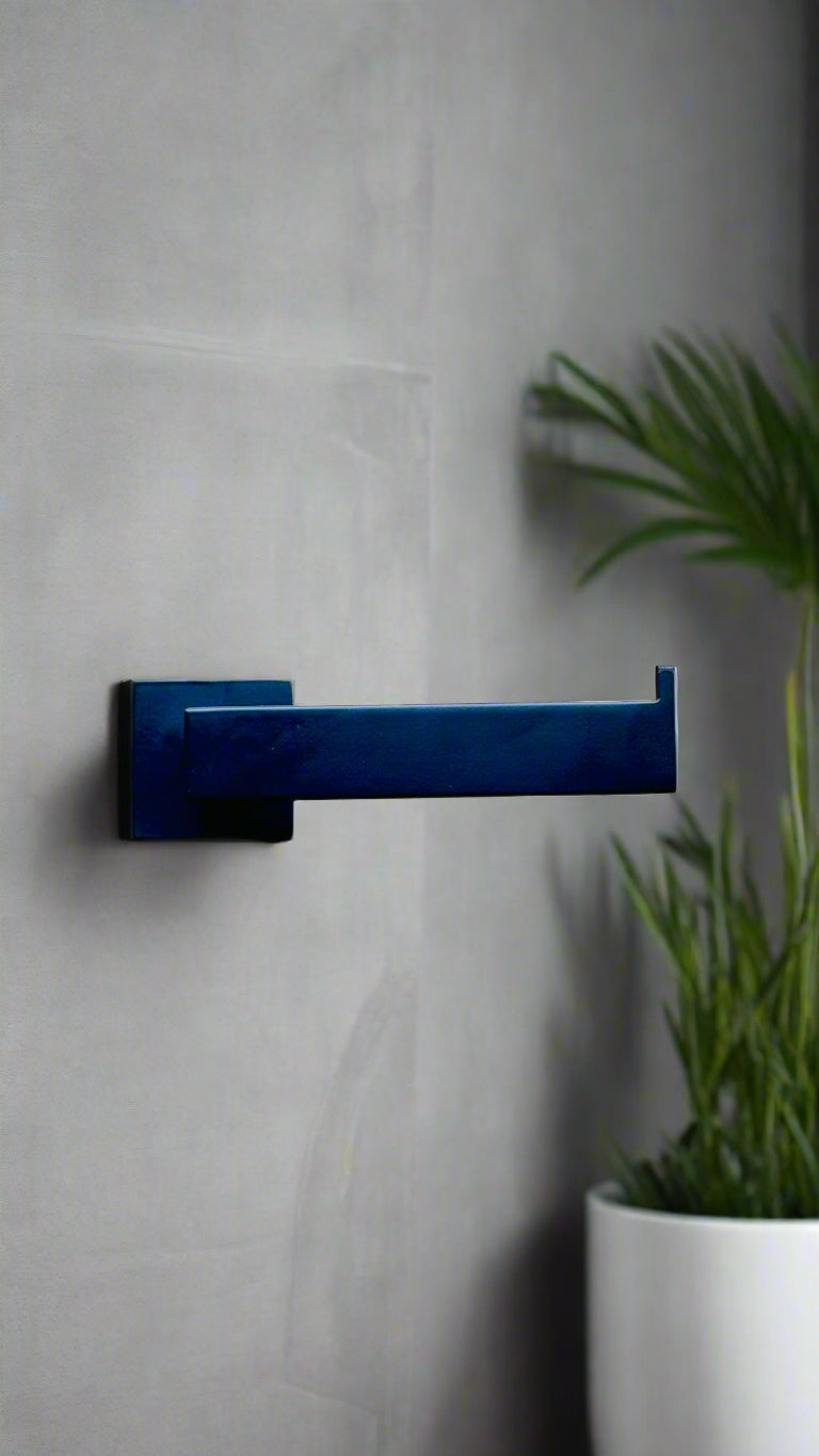 Blue handle on a gray door with a plant in the foreground
