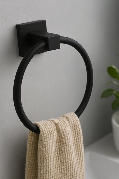 Black towel ring with a beige towel on a gray wall.