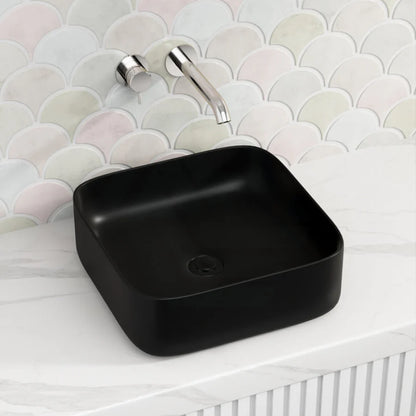Black square sink with silver faucet against a patterned wall