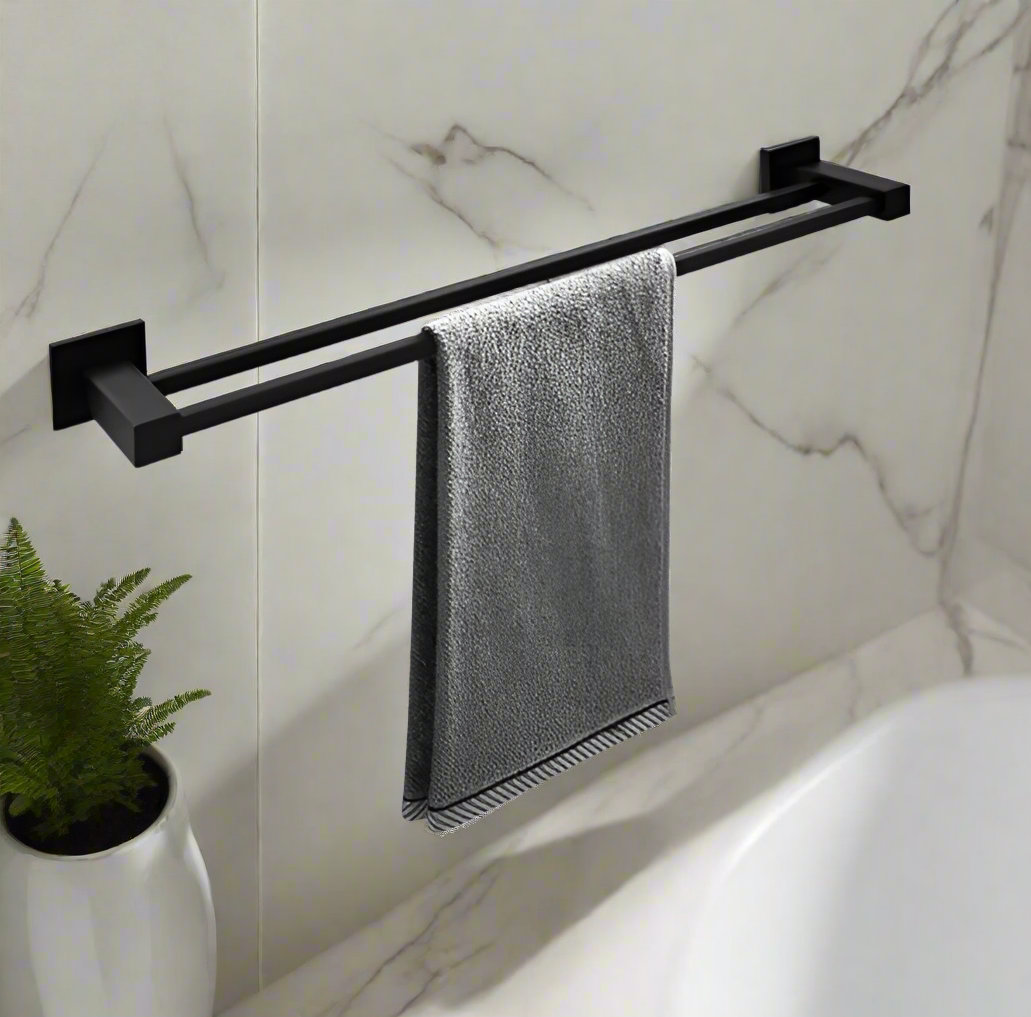Black towel rack with a gray towel hanging on it against a marble wall.