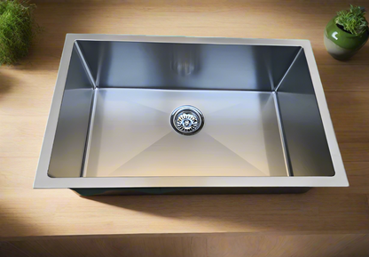 A stainless steel kitchen sink designed for under/Top/Flush Mount installation, displayed against a wooden background.