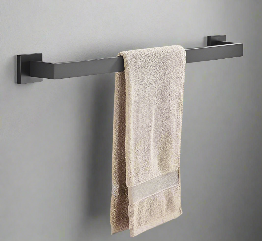 A matte black single towel rack with a square base, mounted on a wall with a towel hanging on it.